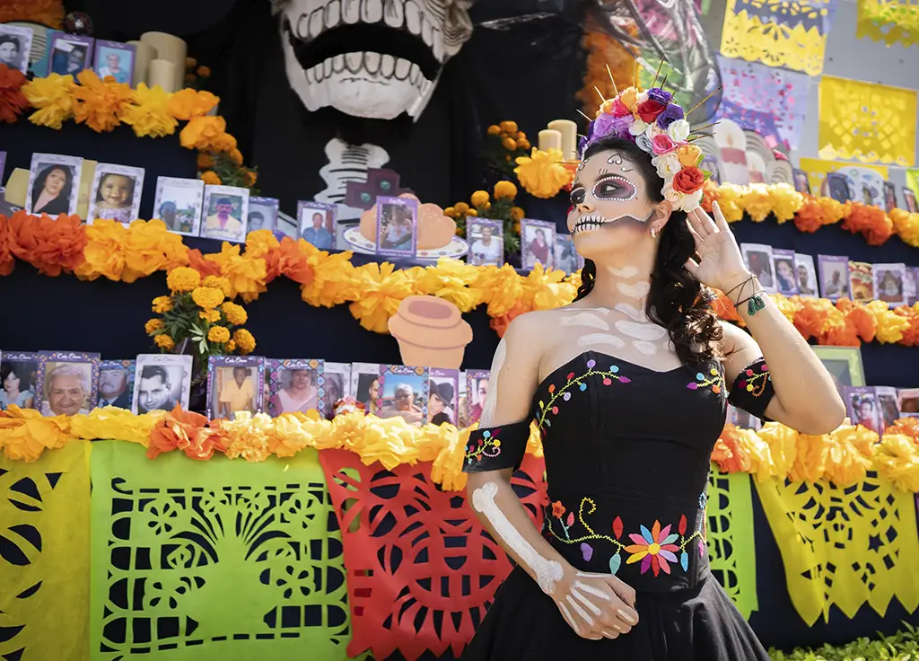 Homenaje colectivo en Colima con altar de fotos y catrina en ceremonia del recuerdo durante festividad mexicana