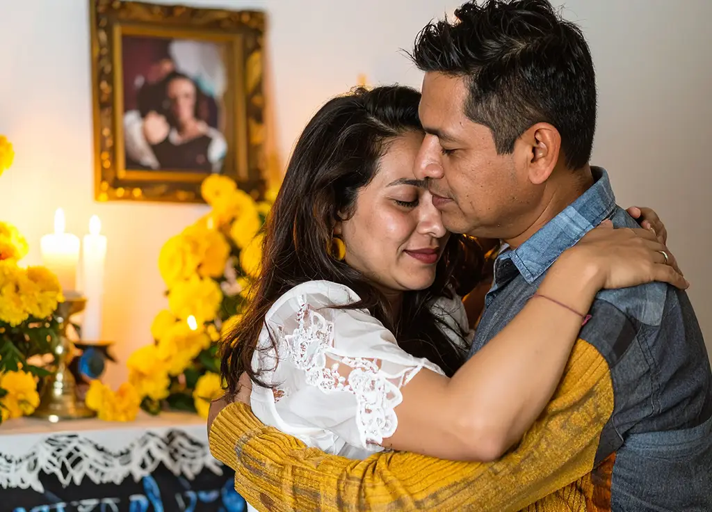 🔹 Ceremonia de despedida personalizada en Manzanillo, pareja abrazándose frente a altar con flores y velas