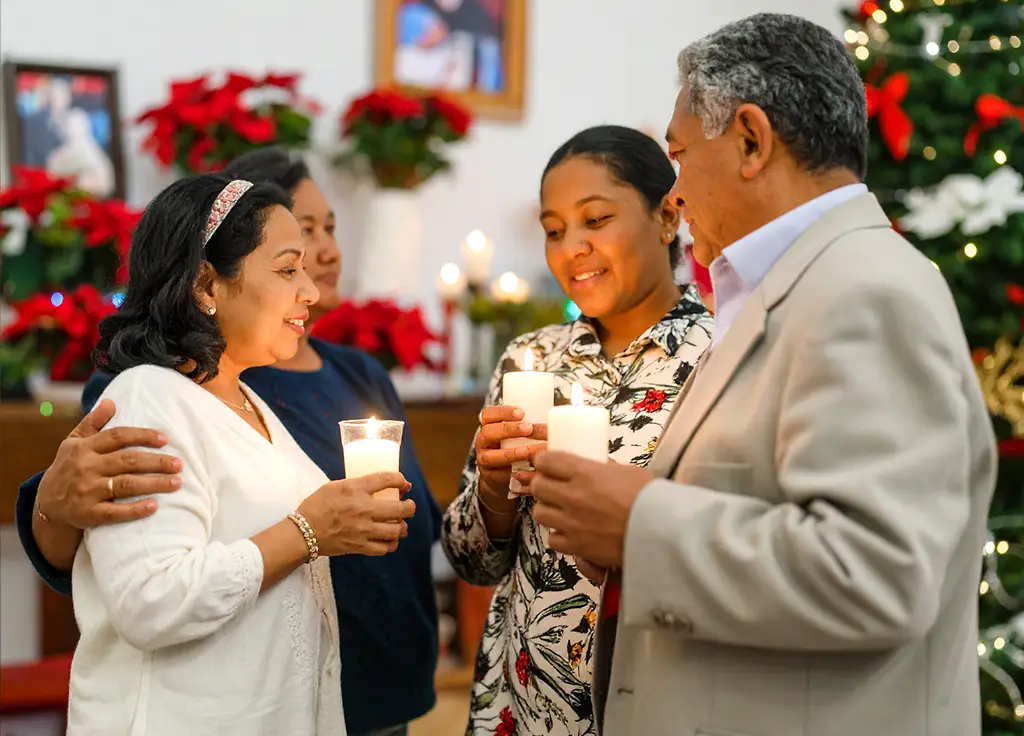 Familia participando en ceremonia del recuerdo colectiva en Navidad, con velas encendidas, nochebuena y árbol decorado, ambiente cálido en Colima